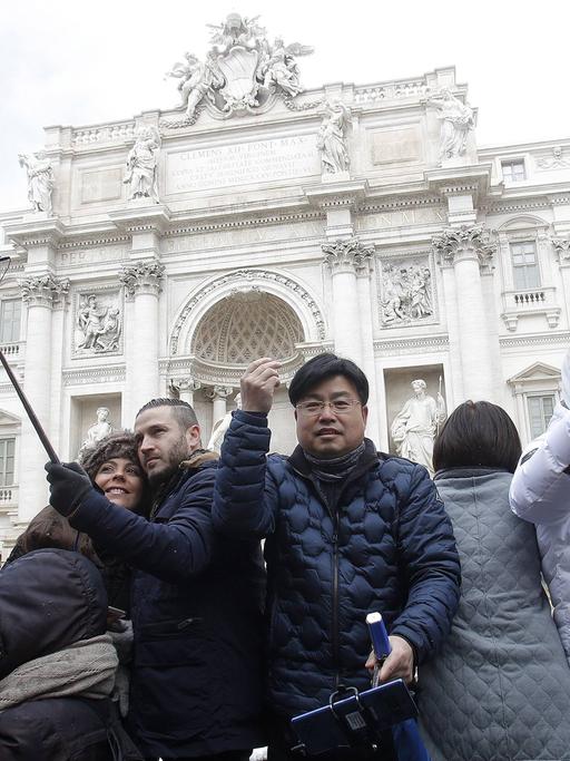 Touristen machen vor dem Trevi-Brunnen in Rom Selfies.