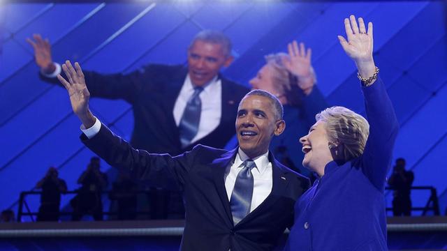 US-Präsident Barack Obama und Präsidentschaftsbewerberin Hillary Clinton umarmen sich auf dem Parteitag der US-Demokraten und winken den Delegierten zu.