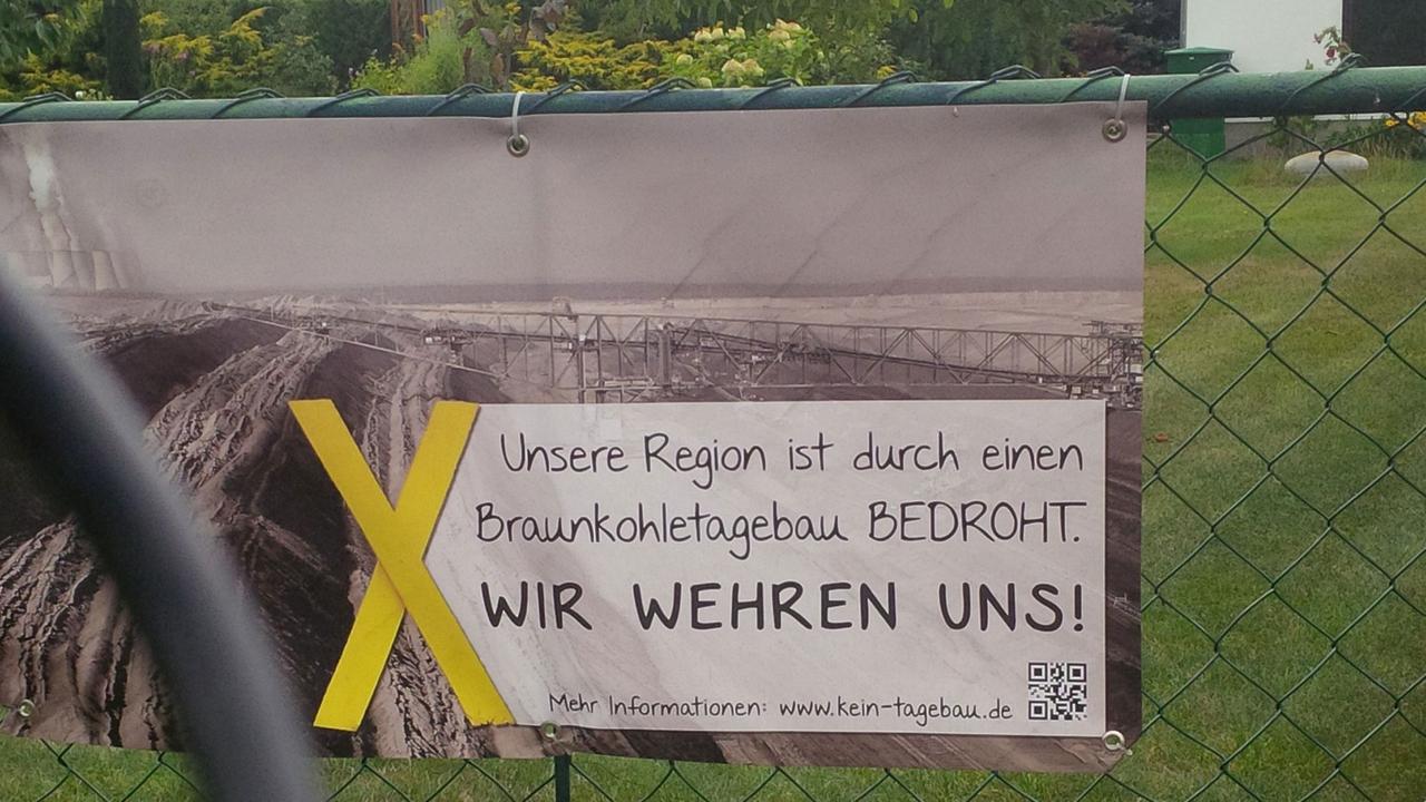 Protestschild: "Unsere Region ist durch einen Braunkohletagebau bedroht. Wir wehren uns!" Protestschild: "Unsere Region ist durch einen Braunkohletagebau bedroht. Wir wehren uns!"