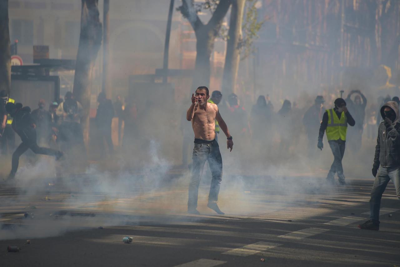Anhänger der Gelbwesten-Bewegung stehen bei den Protesten in Toulouse in einem Nebel aus Tränengas. Anhänger der Gelbwesten-Bewegung stehen bei den Protesten in Toulouse in einem Nebel aus Tränengas.