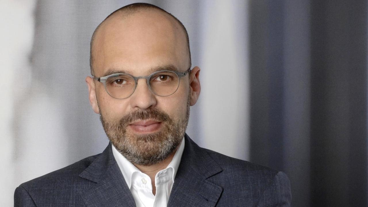 Porträt des Philosophen Christian Bermes, in offenem weißem Hemd und grauem Sakko Porträt des Philosophen Christian Bermes, in offenem weißem Hemd und grauem Sakko