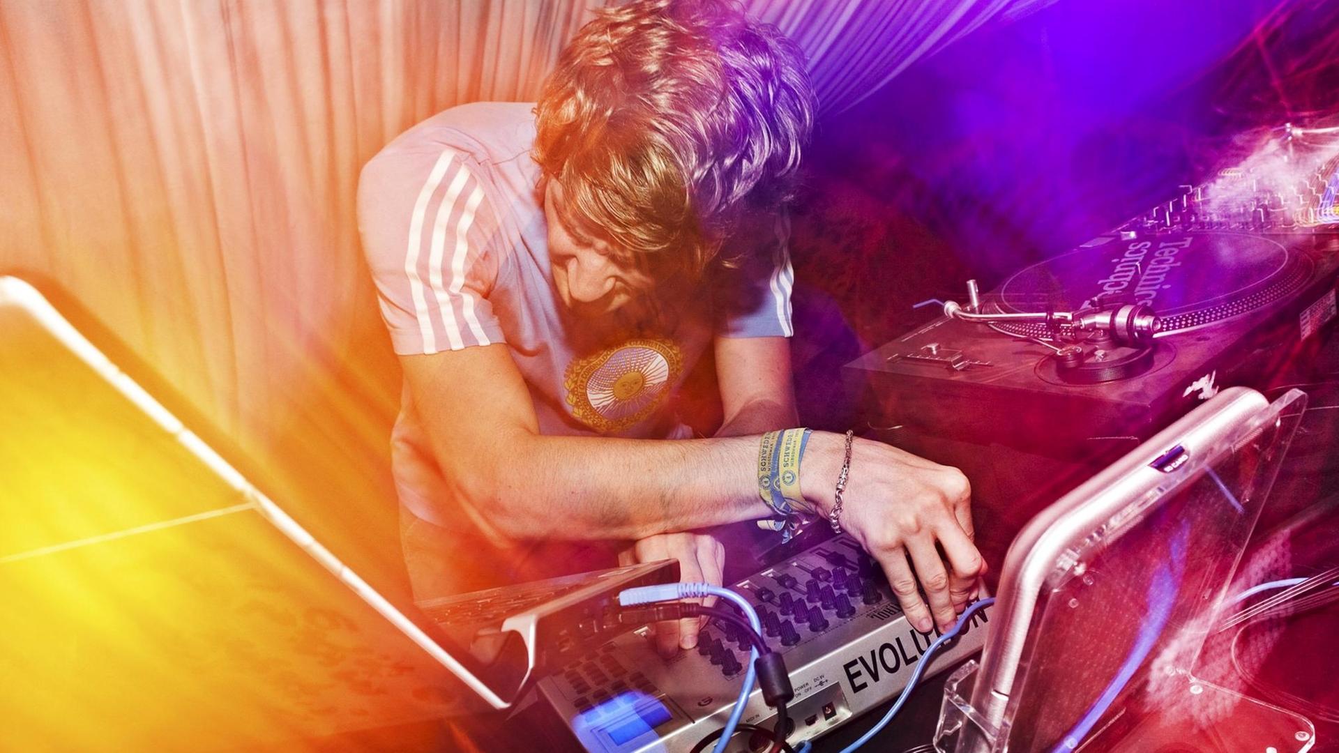 Ein DJ an einem Mischpult in einem Club. Ein DJ an einem Mischpult in einem Club.