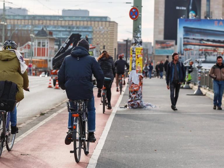 Fahrradfahrer fahren auf dem Radweg der Warschauer Brücke, Berlin
