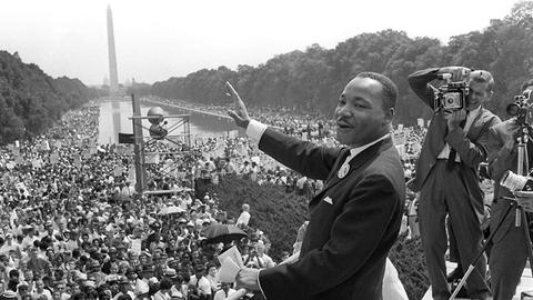 Martin Luther King am 28. August 1963 in Washington, D. C. winkt den Demonstranten zu.