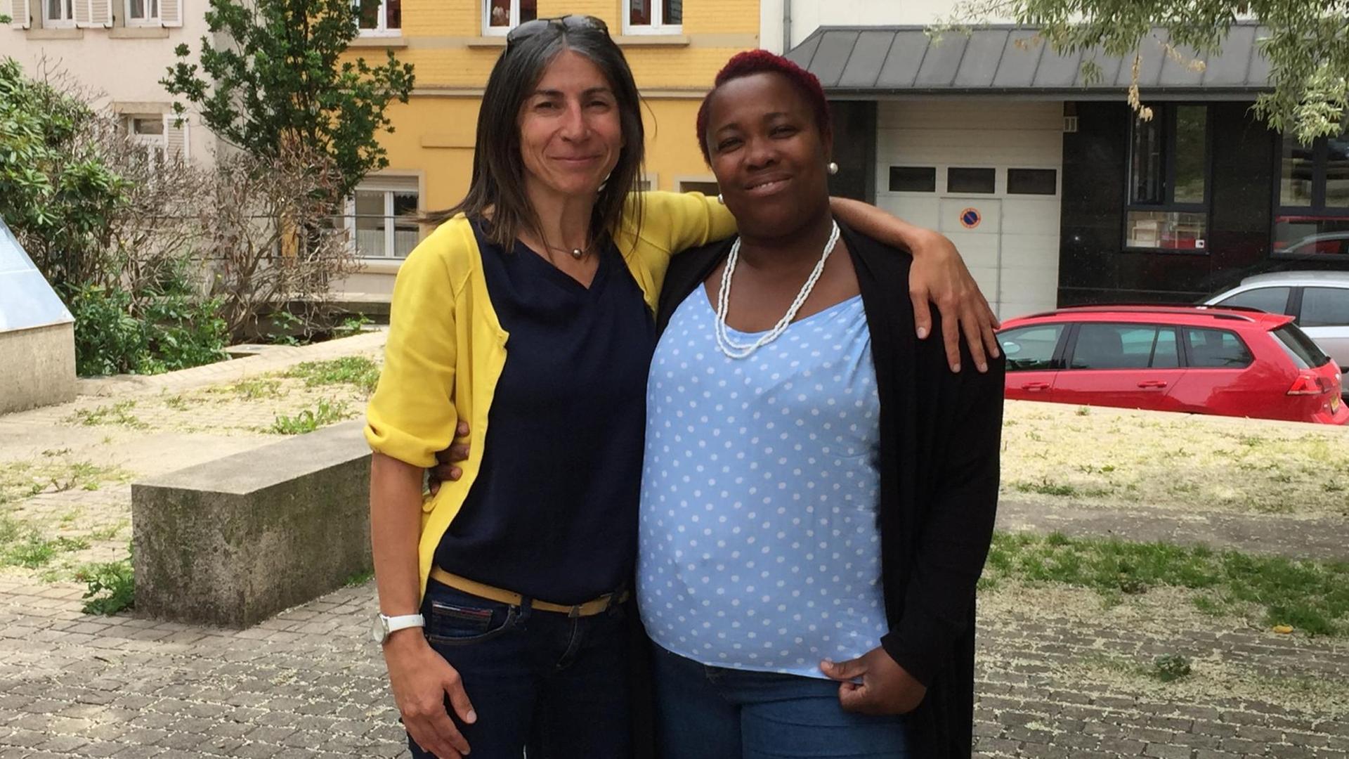 Zwei Frauen stehen Arm in Arm auf der Straße Zwei Frauen stehen Arm in Arm auf der Straße