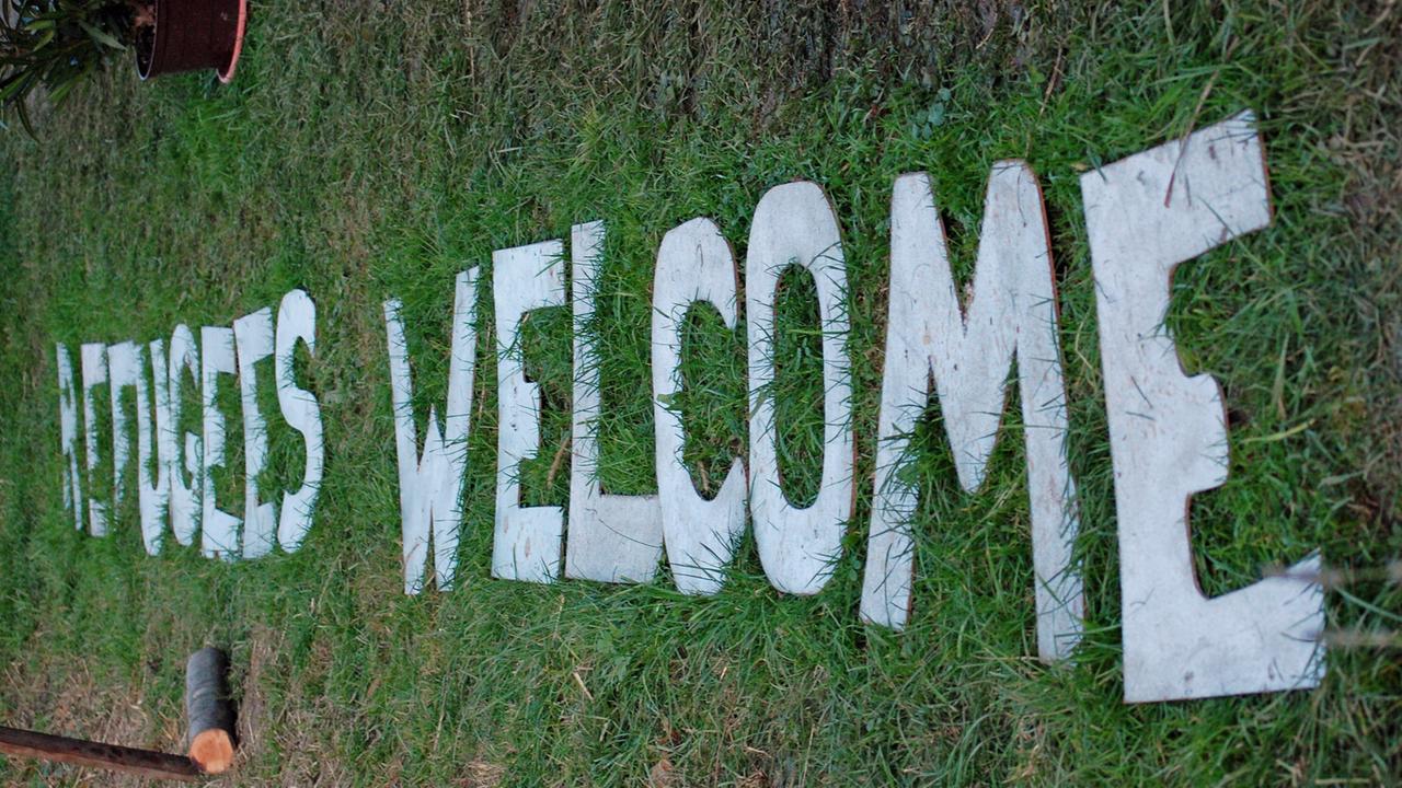 "Refugees welcome" steht in weißen Buchstaben auf dem Rasen. "Refugees welcome" steht in weißen Buchstaben auf dem Rasen.