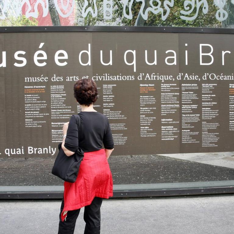 Touristin vor einer Infotafel am Musee du Quai Branly in Paris