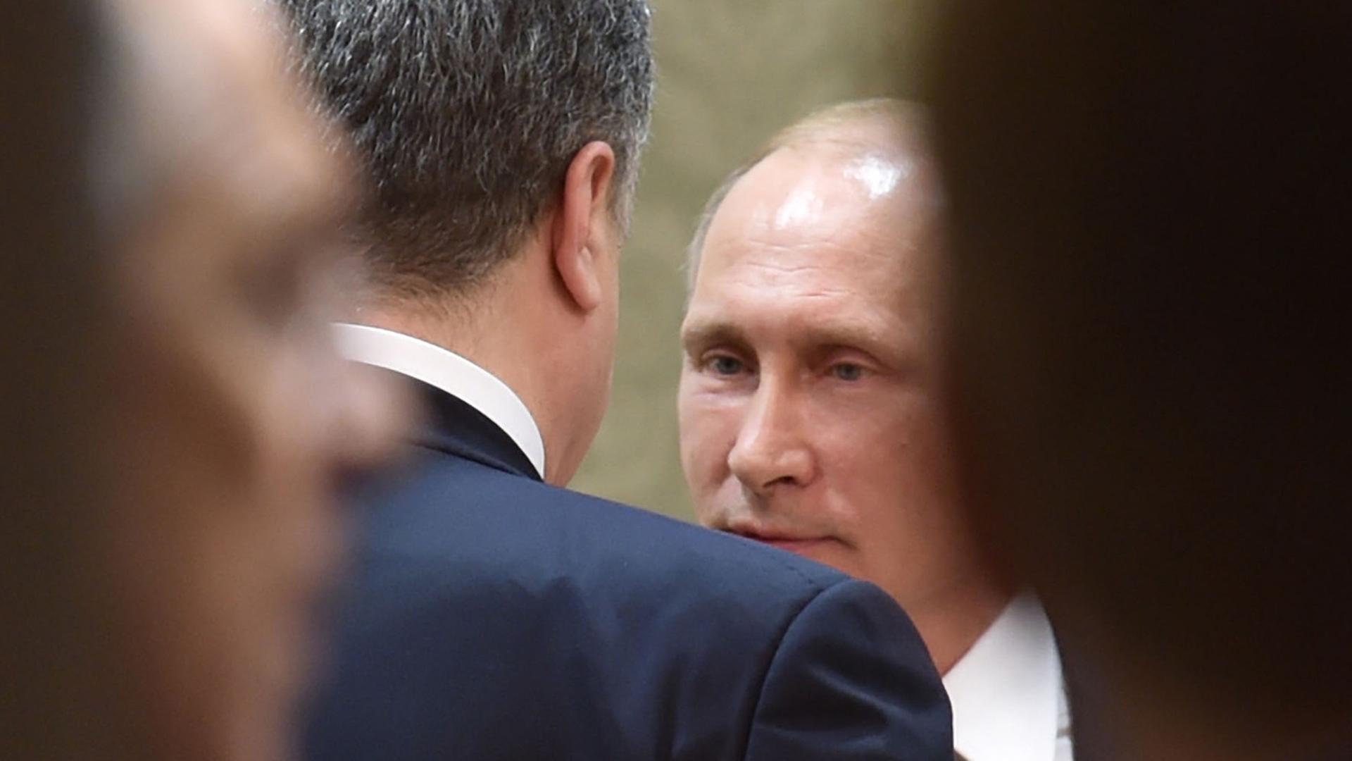 Der russische Präsident Wladimir Putin (hinten) spricht während des Minsker Ukraine-Gipfels mit dem ukrainischen Staatschef Petro Poroschenko. Der russische Präsident Wladimir Putin (hinten) spricht während des Minsker Ukraine-Gipfels mit dem ukrainischen Staatschef Petro Poroschenko.