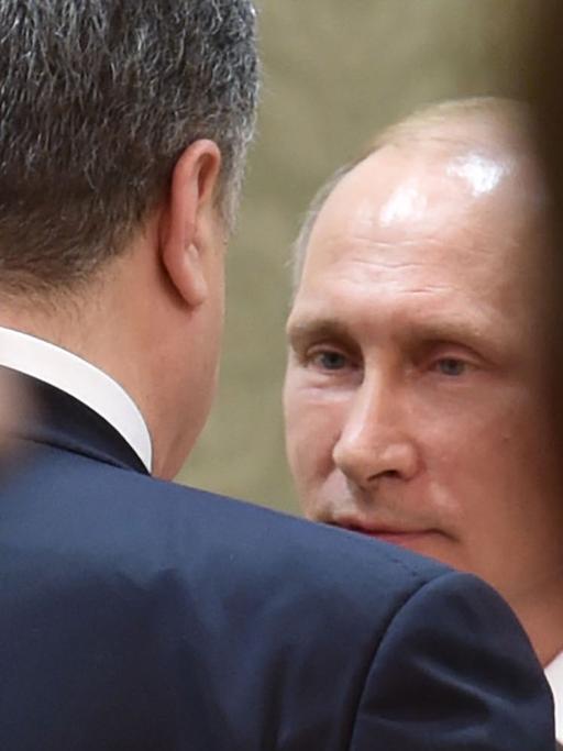 Der russische Präsident Wladimir Putin (hinten) spricht während des Minsker Ukraine-Gipfels mit dem ukrainischen Staatschef Petro Poroschenko.