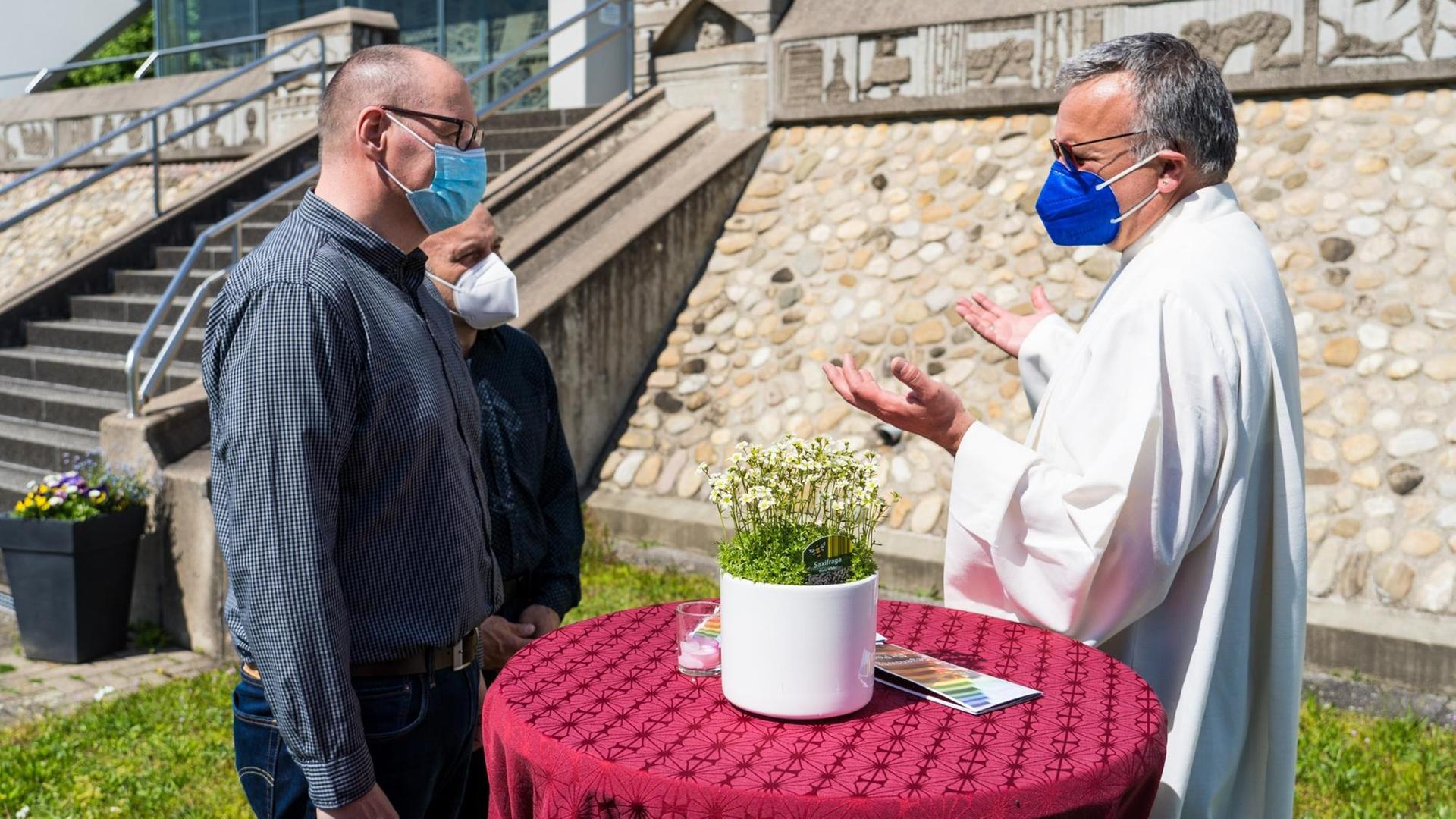 Das Foto zeigt einen Priester, der ein homo-sexuelles Paar segnet. Das Foto zeigt einen Priester, der ein homo-sexuelles Paar segnet.