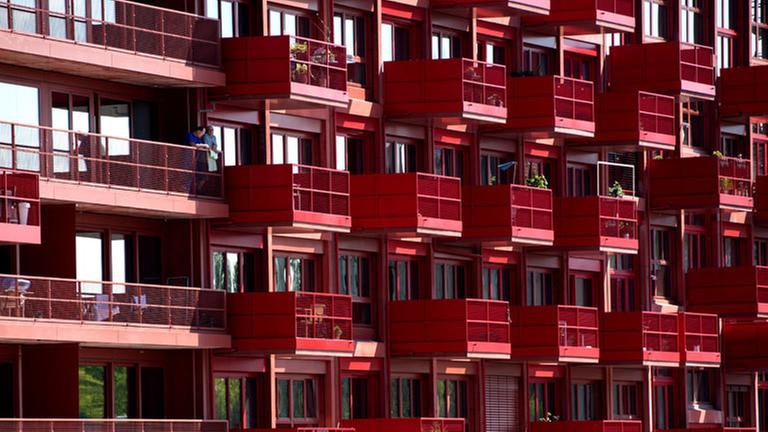Ein rotes Mietshaus mit vielen Balkonen. Ein rotes Mietshaus mit vielen Balkonen.