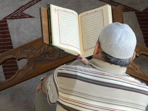 Ein Mann liest im Koran