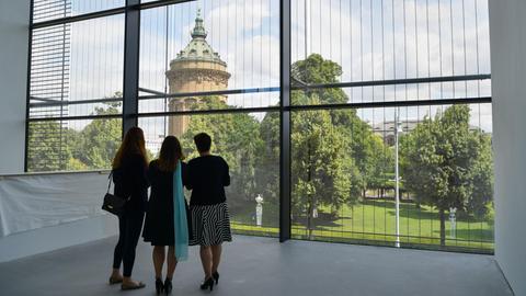 Besucher betrachten am 15.07.2017 in Mannheim durch ein Panoramafenster des Neubaus der Kunsthalle den Mannheimer Wasserturm.