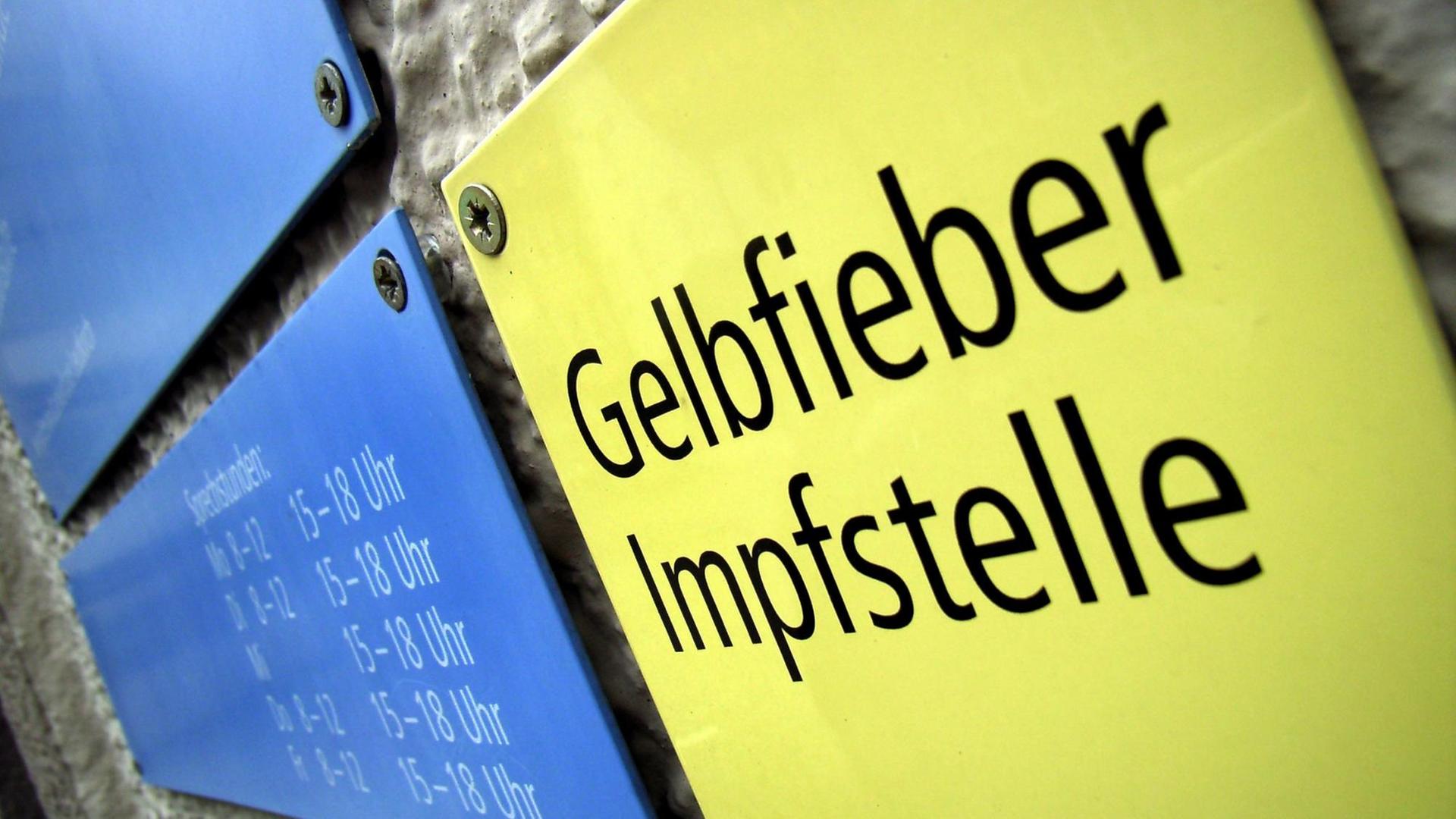 Ein gelbes Schild mit der Aufschrift "Gelbfieber Impfstelle" Ein gelbes Schild mit der Aufschrift "Gelbfieber Impfstelle"