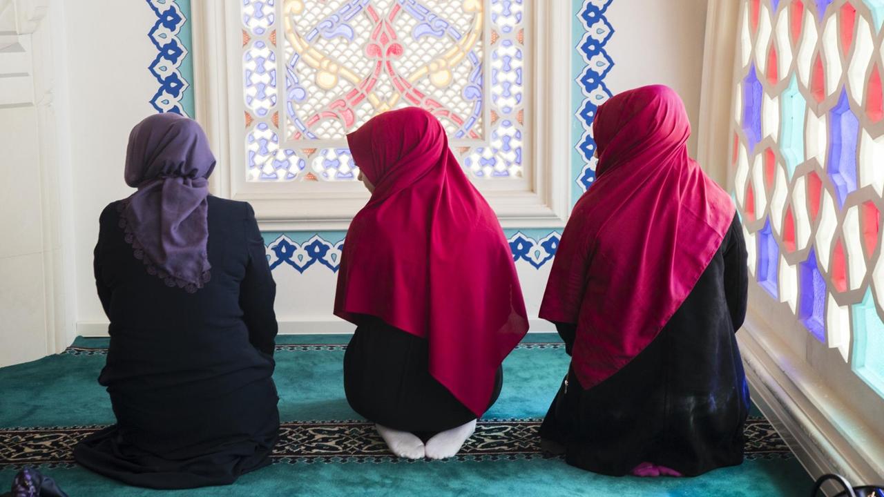 Drei junge Frauen beten in der Sehitlik Moschee in Berlin Neukölln, 2017. Drei junge Frauen beten in der Sehitlik Moschee in Berlin Neukölln, 2017.