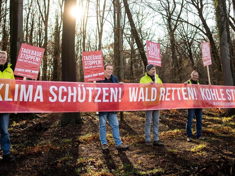 Die Demonstranten in gelben Warnwesten halten ein Transparent mit der Aufschrift "Klima schützen! Wald retten! Kohle stoppen!".