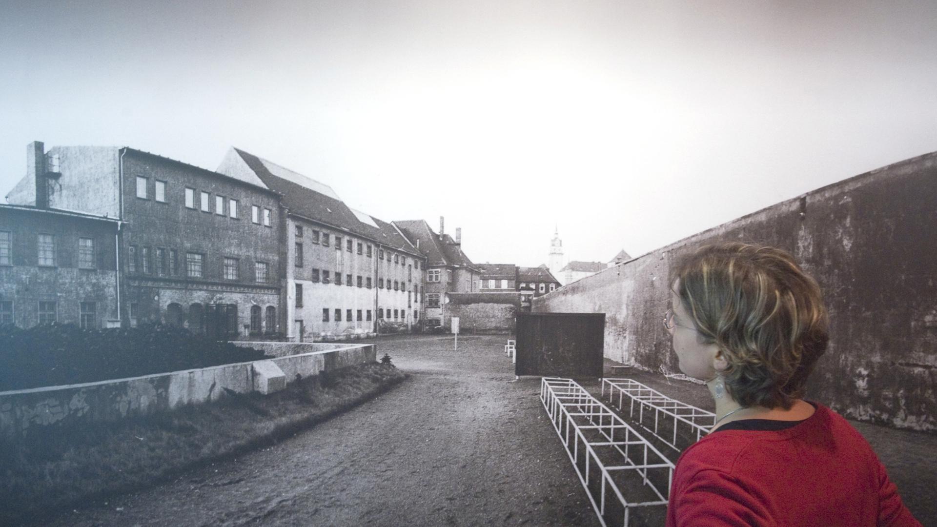 Eine Frau schaut sich am 07.11.2009 eine Fotografie des Innenhofes des ehemaligen Geschlossenen Jugendwerkhofes Torgau in der heutigen Gedenkstätte in Torgau an.