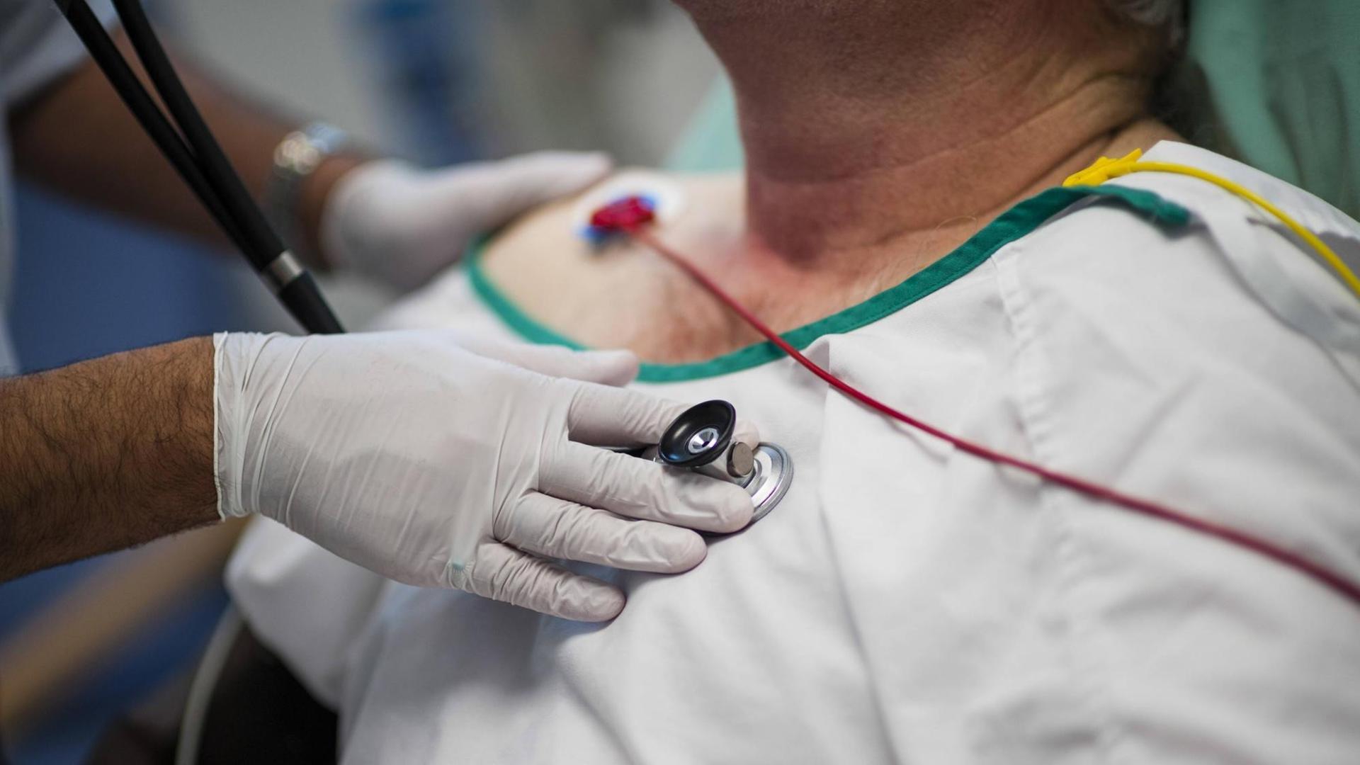 In einem Krankenhaus in Wales, Großbritannien, hört ein Arzt einen Patienten ab In einem Krankenhaus in Wales, Großbritannien, hört ein Arzt einen Patienten ab