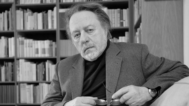 Der Schriftsteller Ror Wolf sitzt am Dienstag (26.02.2008) in seiner Wohnung in Mainz vor einem Bücherregal auf einem Sofa.
