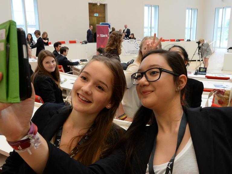 Teilnehmerinnen der Nationalen Auswahlsitzung des Europäischen Jugendparlamentes (EJP) fotografieren sich am 27.05.2014 im Plenarsaal des Landtages in Potsdam (Brandenburg).