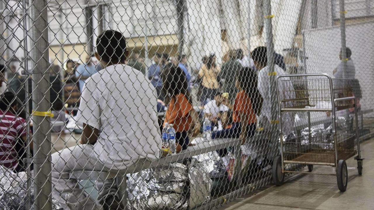 Die von der US-Grenzschutzbehörde zur Verfügung gestellte Aufnahme zeigt Menschen, die im Zusammenhang mit illegalen Grenzübertritten in die USA in Gewahrsam genommen wurden und in einem Käfig sitzen. Die von der US-Grenzschutzbehörde zur Verfügung gestellte Aufnahme zeigt Menschen, die im Zusammenhang mit illegalen Grenzübertritten in die USA in Gewahrsam genommen wurden und in einem Käfig sitzen.