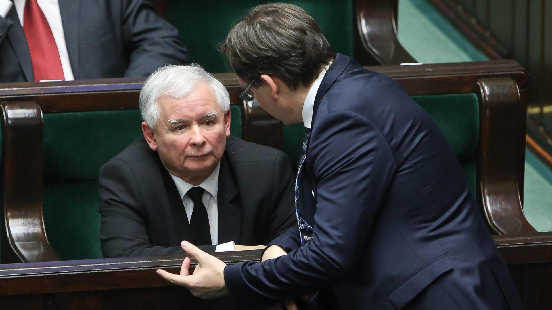 Jaroslaw Kaczynski sitzt auf einer Abgeordnetenbank, Zbigniew Ziobro redet auf ihn ein. Jaroslaw Kaczynski sitzt auf einer Abgeordnetenbank, Zbigniew Ziobro redet auf ihn ein.