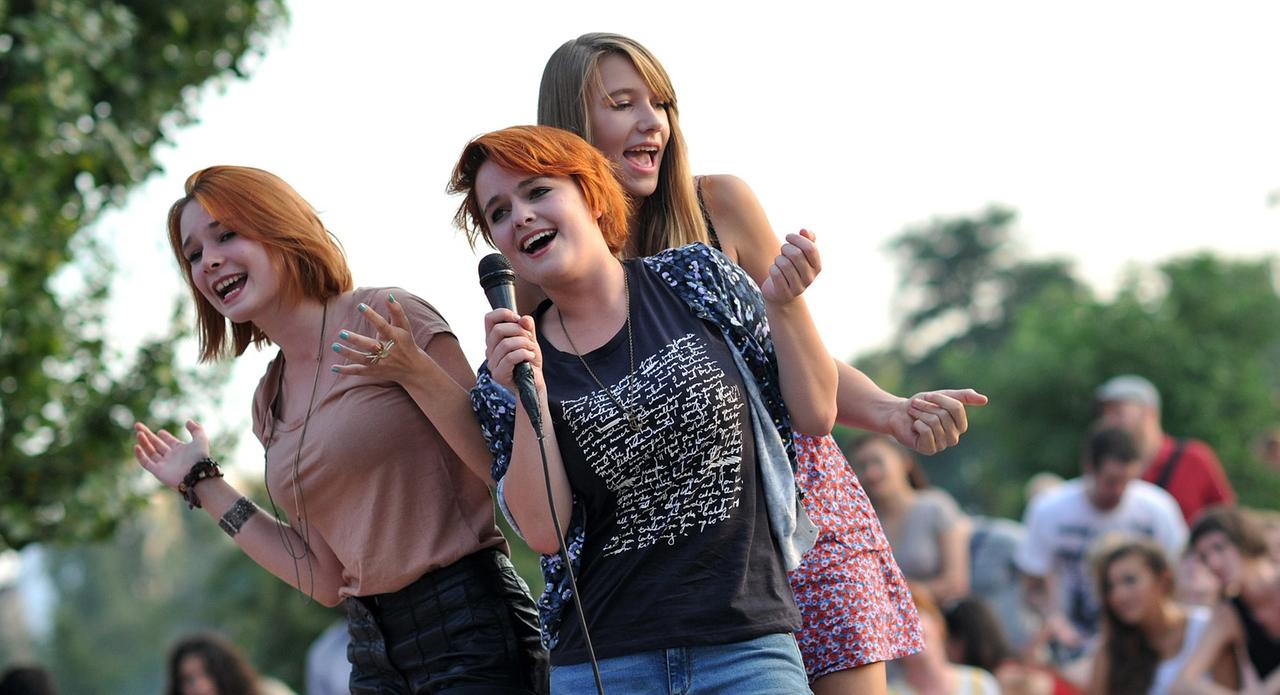 Junge Frauen singen auf der Karaoke-Bühne im Mauerpark in Berlin. 