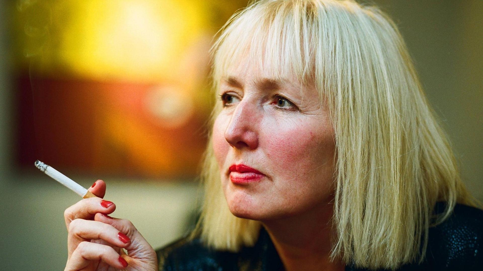 Brigitte Kronauer festgehalten in einem stillen Moment. Sie raucht nachdenklich eine Zigarette. Brigitte Kronauer festgehalten in einem stillen Moment. Sie raucht nachdenklich eine Zigarette.