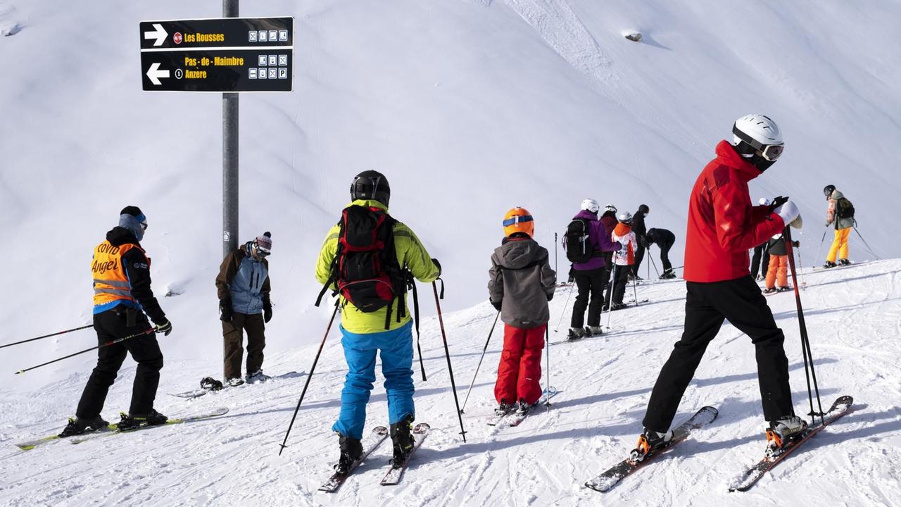 Ein Skilift-Mitarbeiter mit einer "Covid Angel"-Weste auf einer Skipiste in Anzere in der Schweiz im Januar 2021 Ein Skilift-Mitarbeiter mit einer "Covid Angel"-Weste auf einer Skipiste in Anzere in der Schweiz im Januar 2021
