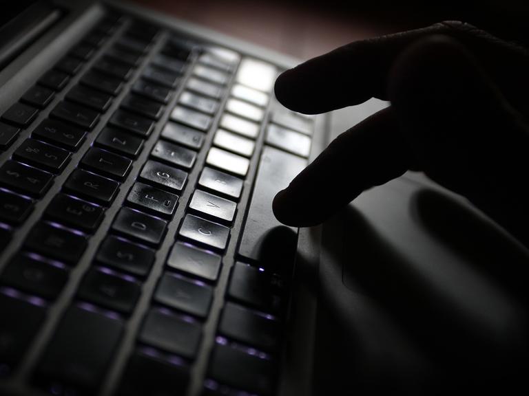 Eine Hand bedient die Tastatur eines Computers.