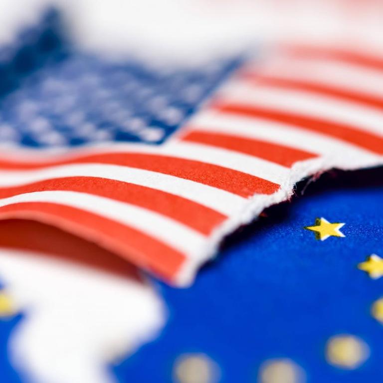 Gerissene Fahnen von den USA und EU, Symbolfoto für drohenden Handelskrieg 