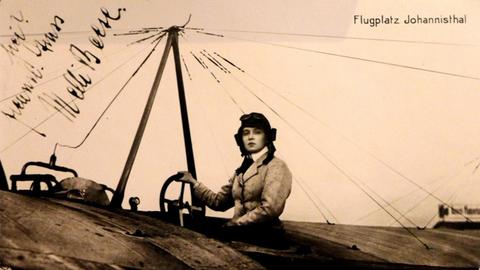 Signierte Postkarte mit einem Foto von von Melli Beese (1886-1925) in einem Flugzeug sitzend mit dem Hinweis "Frl. Beese auf Rumpler-Taube"