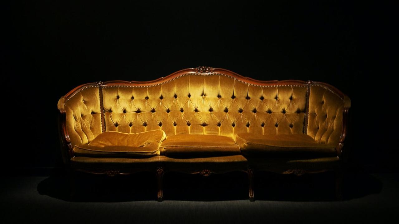 Eine goldenes Sofa in einem Raum.