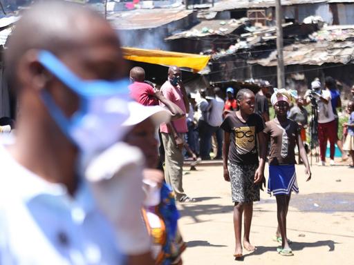 Menschen auf der Straße von Mathare, eine der zahlreichen informellen Siedlungen in der kenianischen Hauptstadt Nairobi