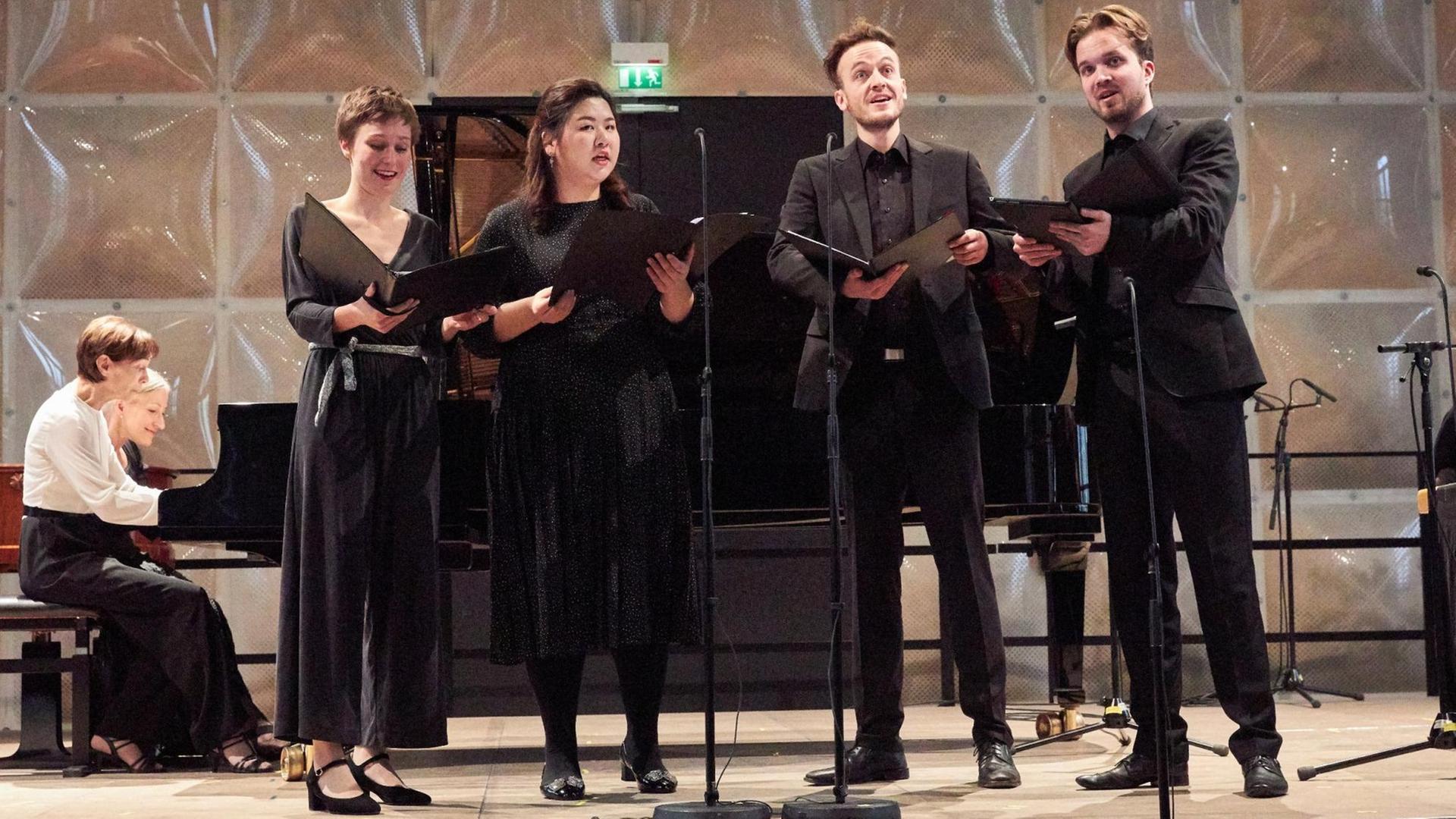 Ein Vokalquartett im Konzert, begleitet von zwei Pianistinnen. Ein Vokalquartett im Konzert, begleitet von zwei Pianistinnen.