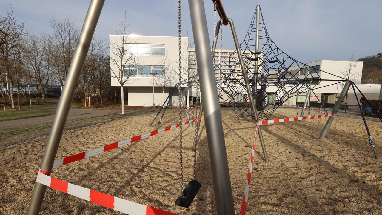 Mit rot-weißem Flatterband ist ein Kinderspielplatz abgesperrt. Mit rot-weißem Flatterband ist ein Kinderspielplatz abgesperrt.