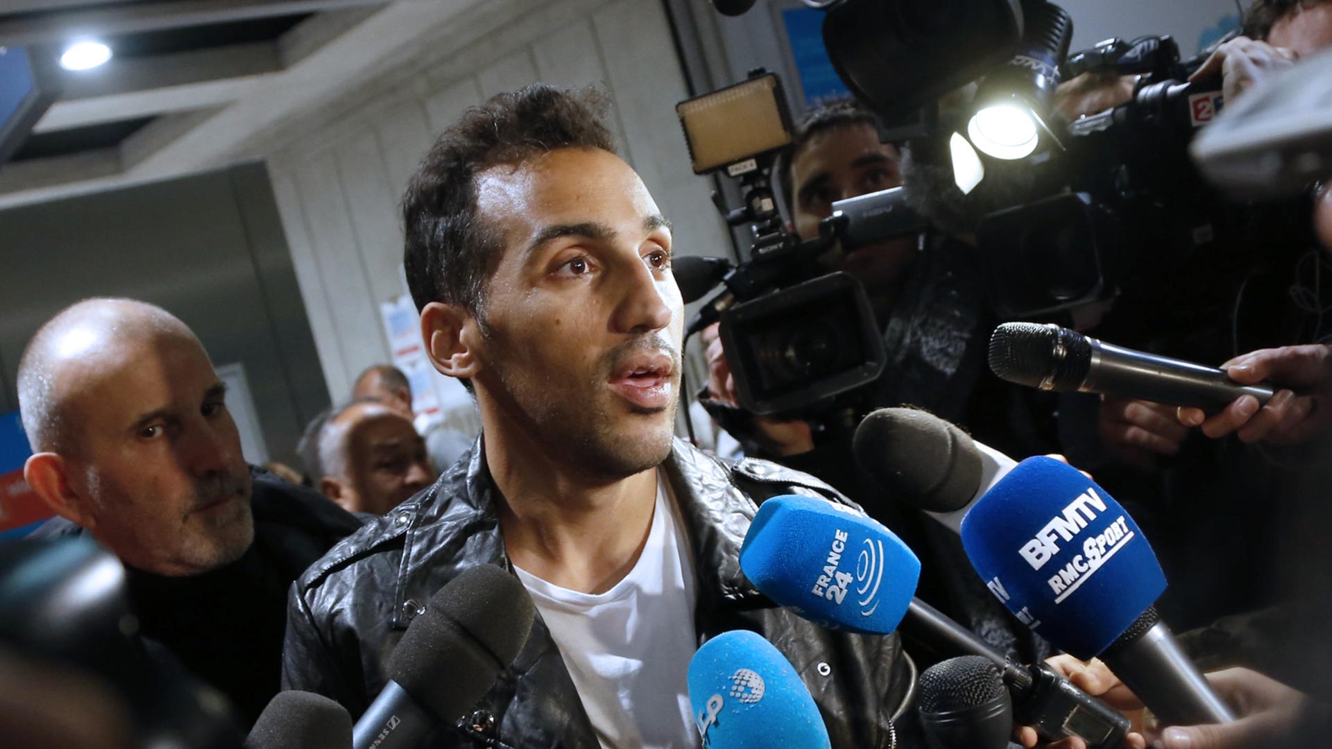 Der französisch-algerische Fußballer Zahir Belounis (33) am 28.11.2013 nach seiner Ankunft in Paris am Flughafen Roissy-Charles-de-Gaulle. Belounis hatte in Katar seit Juni 2012 nicht verlassen können, nachdem er eine Beschwerde gegen seinen Verein Al-Jaish wegen Gehaltszahlungen eingereicht hatte. Der französisch-algerische Fußballer Zahir Belounis (33) am 28.11.2013 nach seiner Ankunft in Paris am Flughafen Roissy-Charles-de-Gaulle. Belounis hatte in Katar seit Juni 2012 nicht verlassen können, nachdem er eine Beschwerde gegen seinen Verein Al-Jaish wegen Gehaltszahlungen eingereicht hatte.