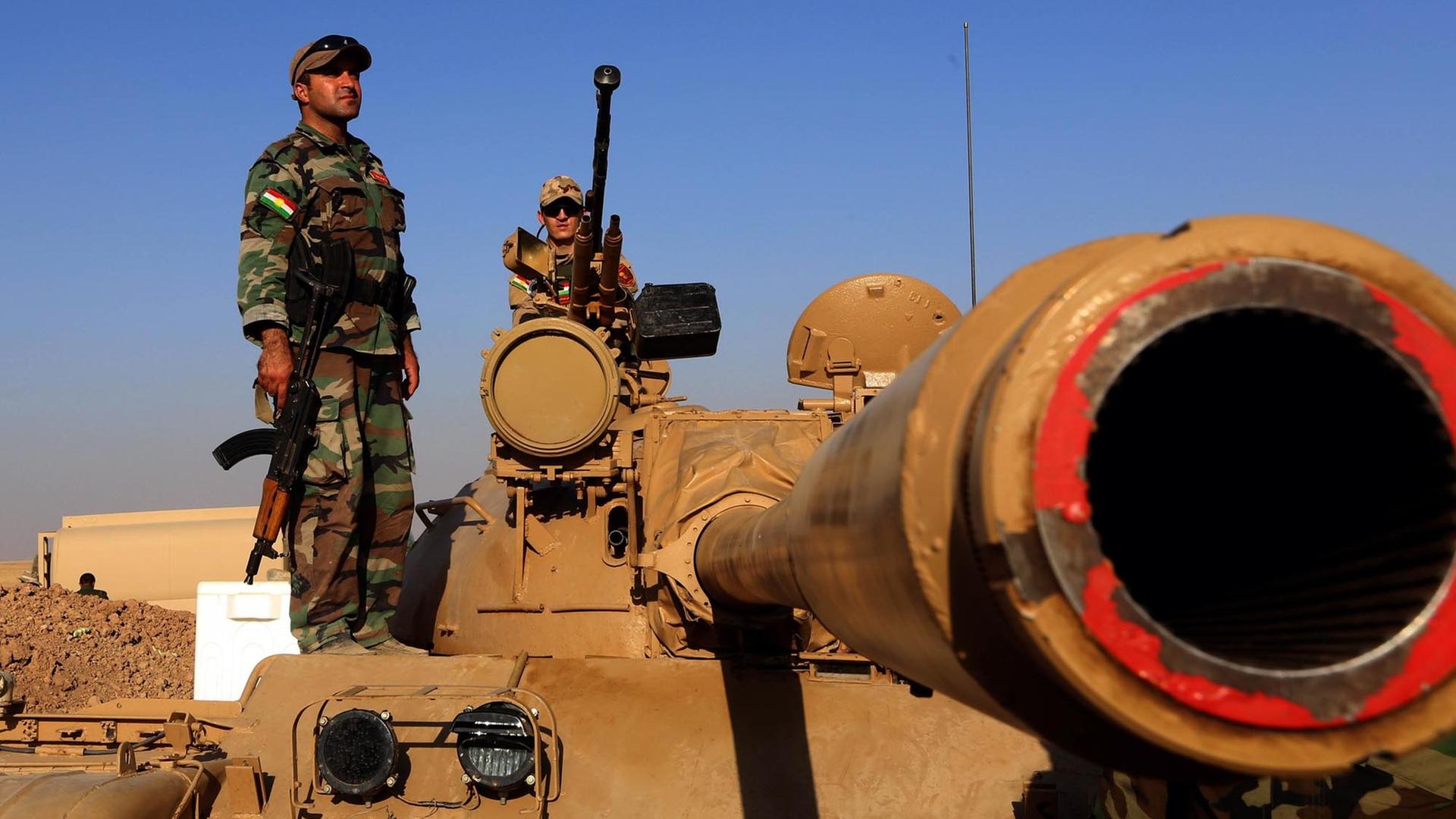 Kurdische Peschmerga-Kämpfer im Nordirak auf einem Panzer nahe der Frontlinie von Khazer, 40 Kilometer westlich von Arbil. Kurdische Peschmerga-Kämpfer im Nordirak auf einem Panzer nahe der Frontlinie von Khazer, 40 Kilometer westlich von Arbil.