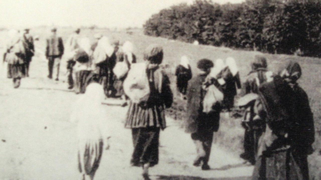 Hungernde Menschen verlassen während der Hungersnot 1932/33 ein ukrainisches Dorf auf der Suche nach Essen.
