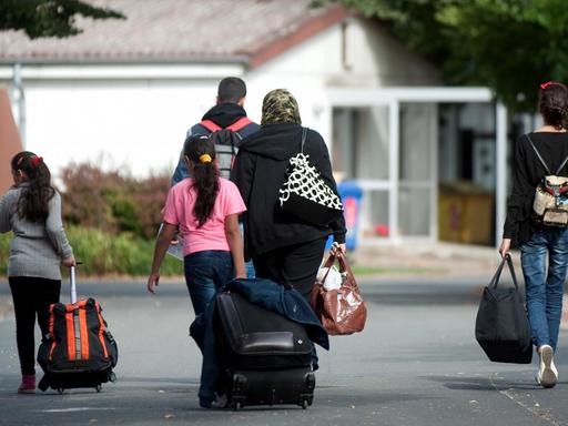 Flüchtlinge mit Koffern und Plastiktüten in Friedland, Niedersachsen.