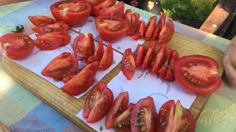 Tomaten liegen aufgeschnitten auf einem Holzbrett. Tomaten liegen aufgeschnitten auf einem Holzbrett.