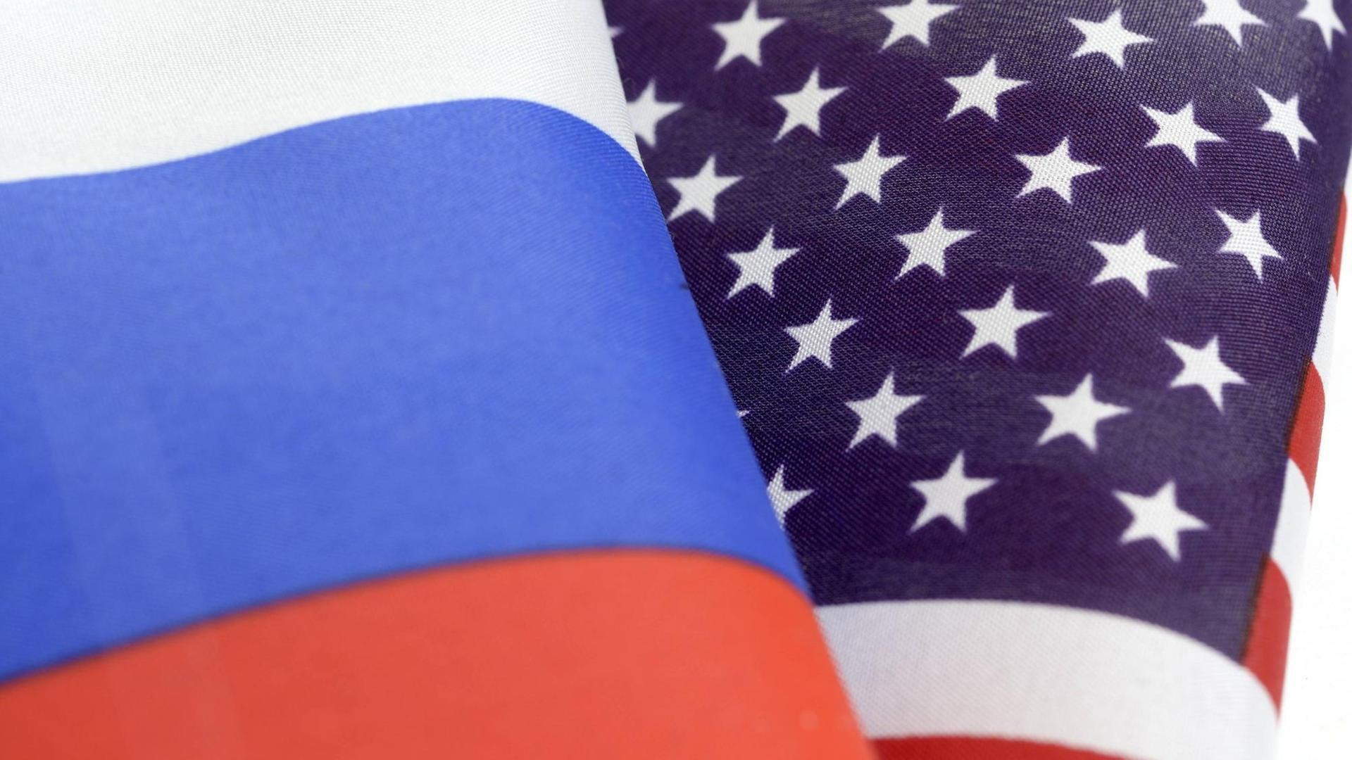 Die Flaggen von Russland und den USA wehen nebeneinander Die Flaggen von Russland und den USA wehen nebeneinander