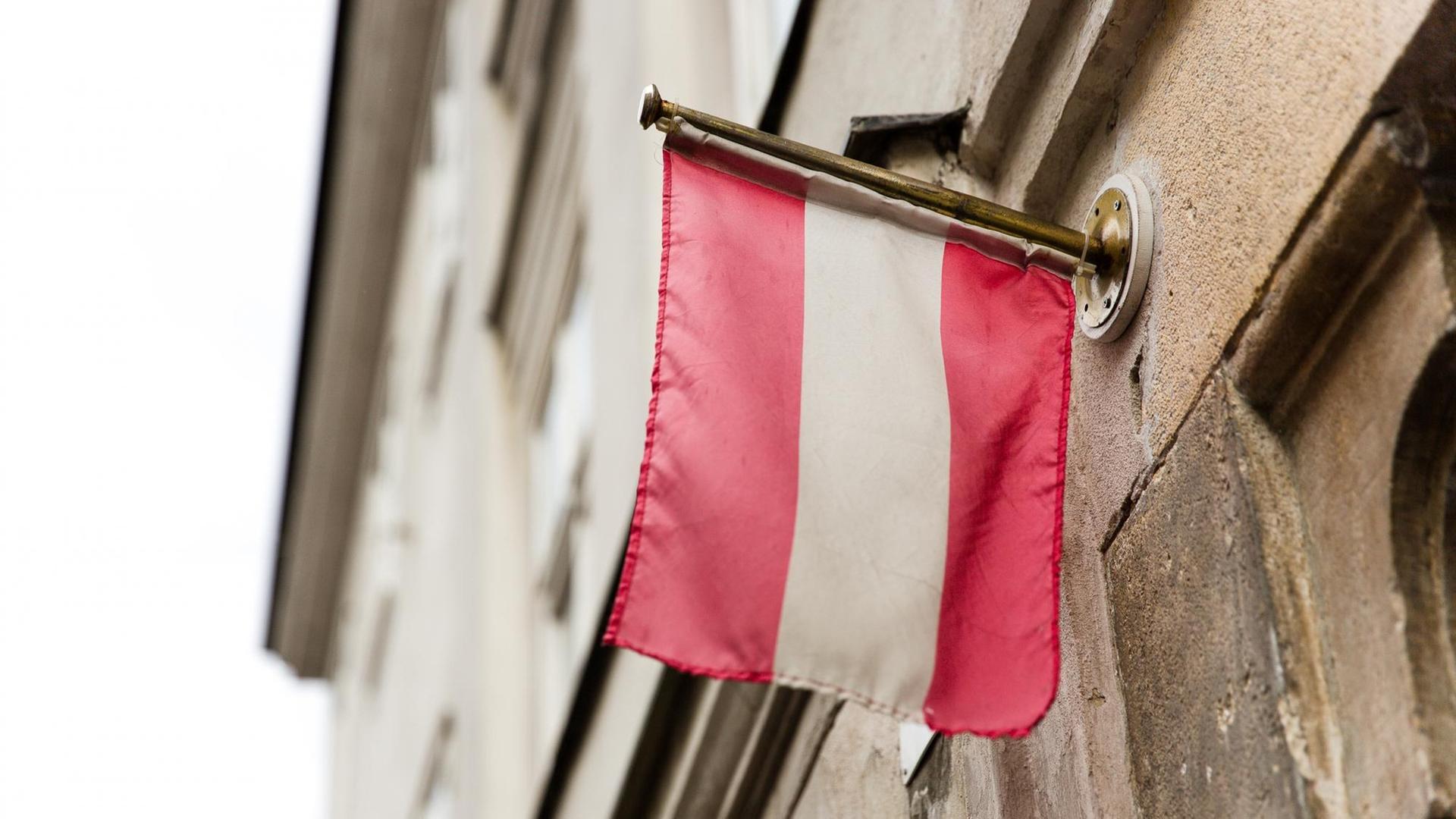 Die Flagge von Österreich hängt an einer Hauswand. Die Flagge von Österreich hängt an einer Hauswand.