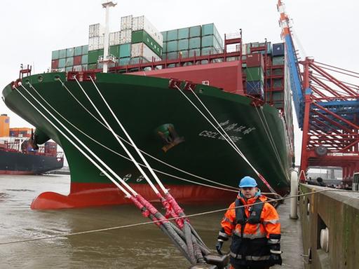 Ein Festmacher arbeitet an den Bugleinen des Containerschiffs "CSCL Globe" bei dem Besuch in Hamburg.