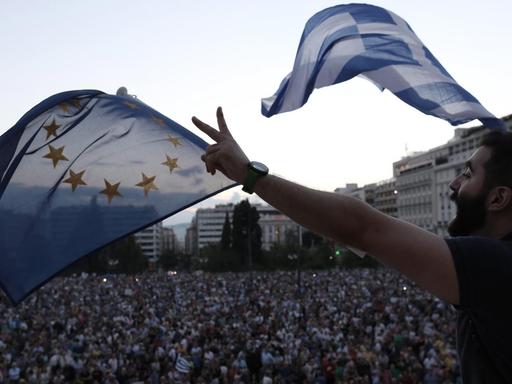 Demonstranten lassen vor dem Parlament Flaggen der EU und Griechenlands wehen.
