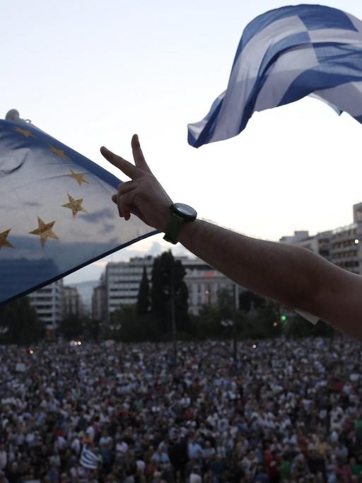 Demonstranten lassen vor dem Parlament Flaggen der EU und Griechenlands wehen.