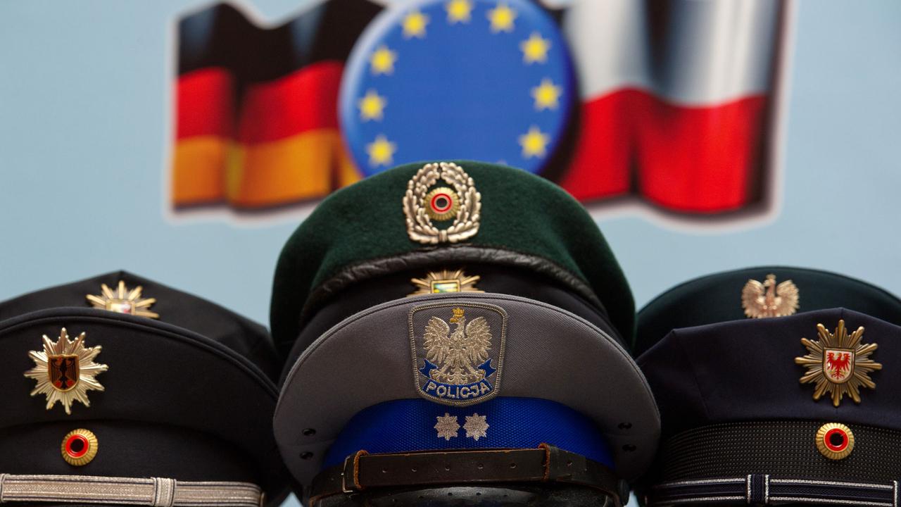 Uniform-Mützen deutscher und polnischer Polizei liegen auf einem Tisch am Rande der deutsch-polnischen Sicherheitstagung in Frankfurt (Oder)