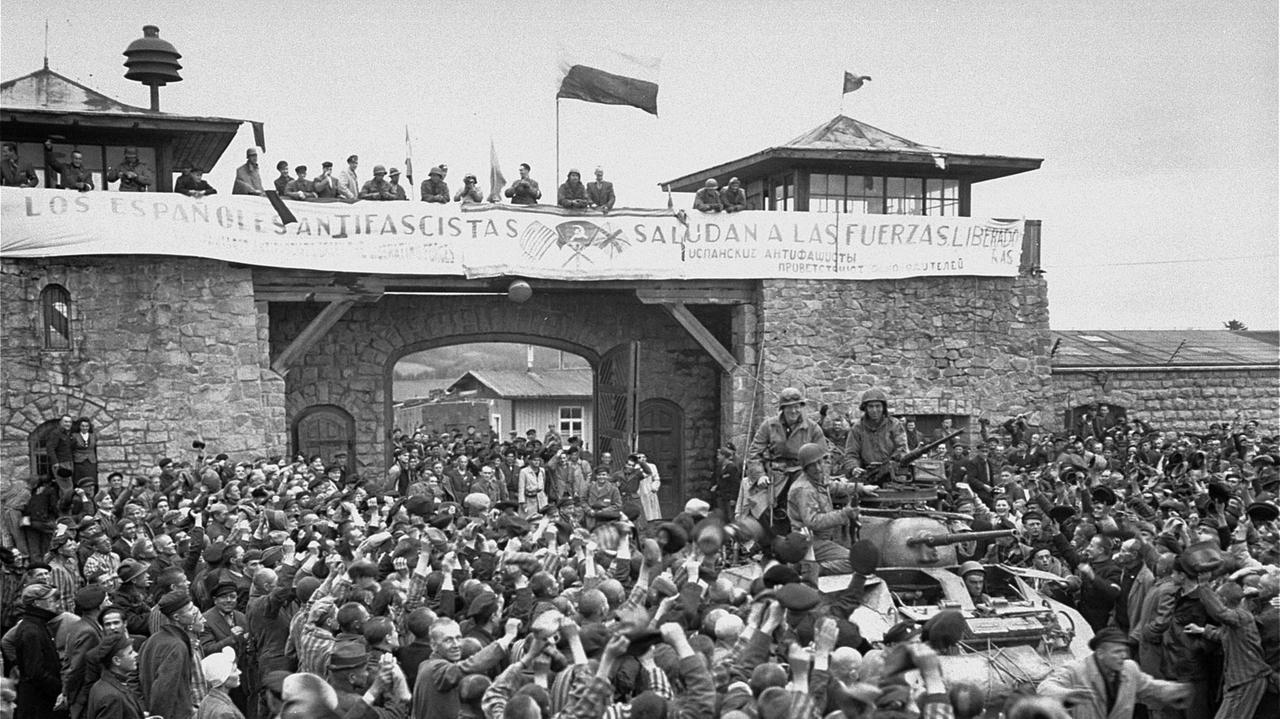 Überlebende Häftlinge jubeln vermutlich am 7. Mai 1945 in einer nachgestellten Szene anläßlich Ihrer Befreiung amerikanischen Soldaten der Elften Panzerdivision zu. Überlebende Häftlinge jubeln vermutlich am 7. Mai 1945 in einer nachgestellten Szene anläßlich Ihrer Befreiung amerikanischen Soldaten der Elften Panzerdivision zu.