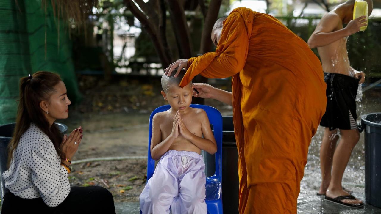 Zu Ehren Königs Bhumibols wurden hunderte Kinder aufs Mönch-Sein vorbereitet. Hier wird einem Jungen im Beisein der Mutter der Kopf rasiert. 