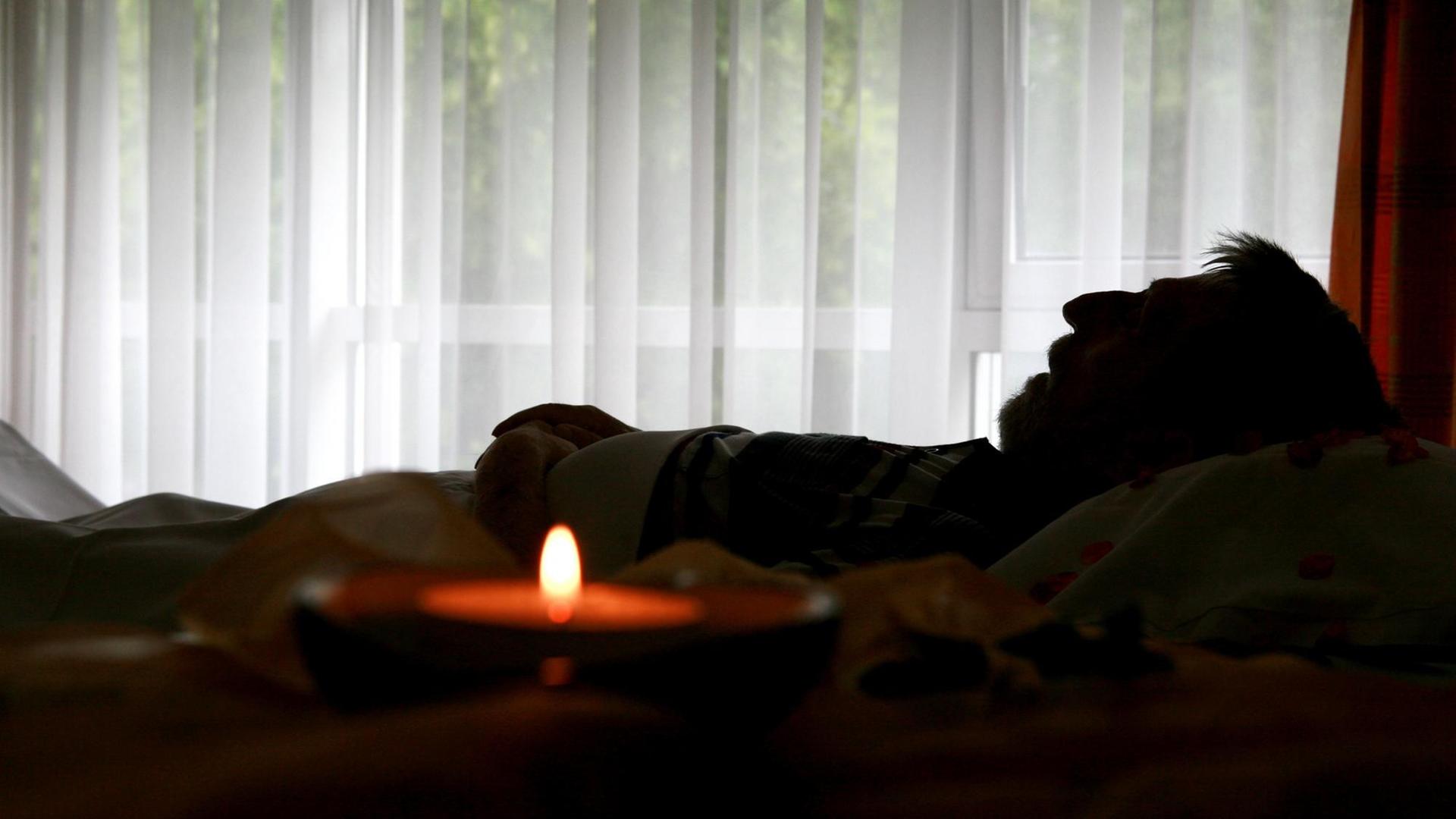 Ein verstorbener Bewohner liegt in seinem Bett im Christophorus Hospiz in München (Oberbayern), neben ihm auf einem Tisch eine brennende Kerze, aufgenommen am 05.06.2008. In einem Hospiz werden unheilbar kranke Patienten, die hier Bewohner genannt werden, palliativ versorgt. (!Veröffentlichung nur im Zusammenhang einer redaktionellen Berichterstattung zum Thema Hospiz). Foto: Tobias Hase dpa/lby +++(c) dpa - Report+++ | Verwendung weltweit Ein verstorbener Bewohner liegt in seinem Bett im Christophorus Hospiz in München (Oberbayern), neben ihm auf einem Tisch eine brennende Kerze, aufgenommen am 05.06.2008. In einem Hospiz werden unheilbar kranke Patienten, die hier Bewohner genannt werden, palliativ versorgt. (!Veröffentlichung nur im Zusammenhang einer redaktionellen Berichterstattung zum Thema Hospiz). Foto: Tobias Hase dpa/lby +++(c) dpa - Report+++ | Verwendung weltweit